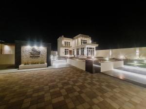 a night view of a building with at PARADISE Villa in Al Sharqiyah
