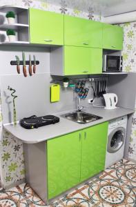 a kitchen with green cabinets and a sink at Stars Hostel in Yaroslavl