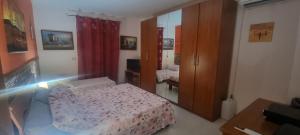 ein kleines Schlafzimmer mit einem Bett und einem Spiegel in der Unterkunft Appartamento in Complesso Sonia in Santa Teresa di Riva