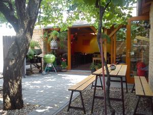 a patio with a picnic table and a tree at Penzion Pitnerka in Hustopeče