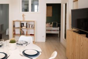 een woonkamer met een tafel en een televisie bij ColorPop - Netflix Wifi Tout équipé - Appart Pézenas Centre in Pézenas