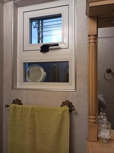 uma janela numa casa de banho com uma toalha verde em Shvili em Buenos Aires