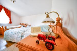 un tractor de juguete rojo en una mesa junto a una cama en Farm Stay Peternelj, en Ilirska Bistrica