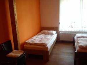a small room with two beds and a window at Penzion Pitnerka in Hustopeče