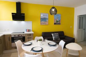 ein Wohnzimmer mit einem Tisch und einem Sofa in der Unterkunft ColorPop - Netflix Wifi Tout équipé - Appart Pézenas Centre in Pézenas
