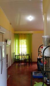 a dining room with a table and a green curtain at Casita El Sonido de las Aves in Uvita