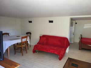 een woonkamer met een rode bank en een tafel bij logement à 50 m de la mer ! in Hermanville-sur-Mer