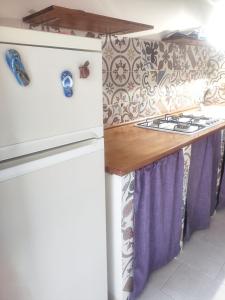 Una cocina con un refrigerador blanco y una encimera. en La nicchia di Mary, en Bisceglie
