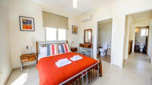- une chambre avec un lit orange et une salle de bains dans l'établissement Kapparis Holiday Villa 018, à Protaras 26 autres photos