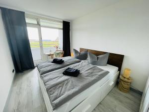 a bedroom with a large bed with two bags on it at Apartment Fischkoker mit Meerblick und Pool in Dahme