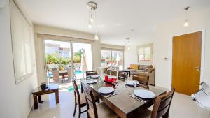 une salle à manger et un salon avec une table et des chaises dans l'établissement Kapparis Holiday Villa 018, à Protaras