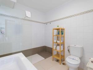 La salle de bains blanche est pourvue de toilettes et d'un lavabo. dans l'établissement Mahostly Apartamento Comillas SB, à Arrecife