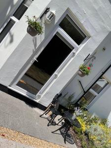 a building with two chairs and a window with plants at Stylish One Bedroom Central Bournemouth Flat in Bournemouth