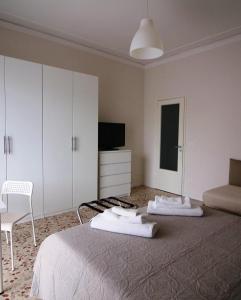 a bedroom with a bed and a chair and a television at Giuffrida Apartment Rooms in Catania