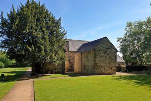 a large brick building with a tree in the yard at The Aldridge 2 Bedroom Apartment with FREE Parking in Ibstock