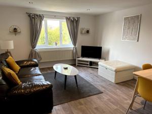 uma sala de estar com um sofá e uma mesa em The Aldridge 2 Bedroom Apartment with FREE Parking em Ibstock