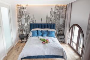 a bedroom with a blue bed with flowers on it at Apartament Latarnik - PIOTRKOWSKA 37 in Łódź