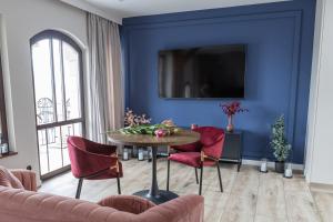 salon z niebieskimi ścianami, stołem i krzesłami w obiekcie Apartament Latarnik - PIOTRKOWSKA 37 w Łodzi
