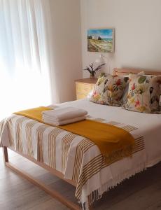 um quarto com uma cama com um cobertor amarelo em Hilton Cove Beach House em Melkbosstrand