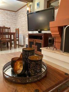 bandeja con 3 tazas en una mesa con TV en Το κατώγι, en Mouresi