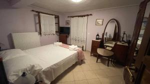 1 dormitorio con 2 camas, lavabo y espejo en Το κατώγι, en Mouresi
