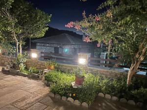 a garden with lights in front of a house at Το κατώγι in Mouresi