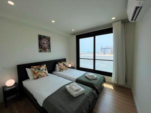 una camera con due letti e una grande finestra di Faro Design 2 by Homing a Faro