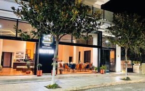 un negozio con un albero davanti di 3B Suites Boutique Hotel a Sarandë