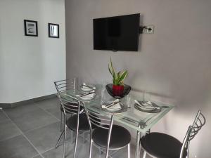 a dining room with a glass table and chairs at Karavela Street Apartment in Preveza