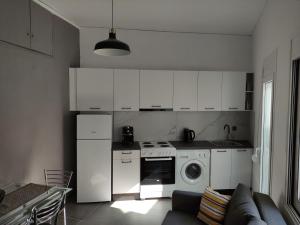 a kitchen with a stove and a washing machine at Karavela Street Apartment in Preveza