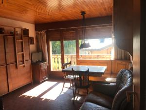 a living room with a table and chairs and a window at Appartement 2 pieces LE SAPPORO in Les Gets