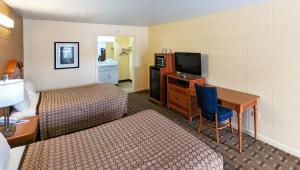 a hotel room with a bed and a desk and a television at M Star Hotel Cleveland in Cleveland