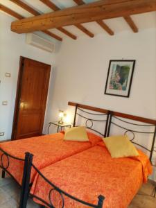 una camera da letto con un letto e un piumone arancione di Agriturismo Il Colto a San Gimignano