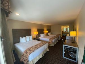 a hotel room with two beds and a desk at Garden State Inn in Absecon