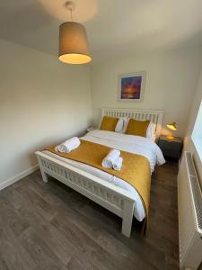 a bedroom with a bed with two towels on it at The Aldridge 2 Bedroom Apartment with FREE Parking in Ibstock