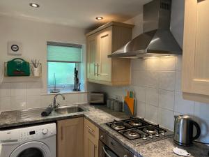 kuchnia ze zlewem i kuchenką górny piekarnik w obiekcie The Aldridge 2 Bedroom Apartment with FREE Parking w mieście Ibstock +15 zdjęć
