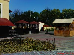 a group of buildings in a courtyard with trees at Pallada Motel in Pasiky-Zubryts'ki