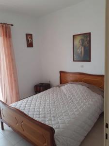 a bed in a bedroom with a picture on the wall at Vasiliki's apartment in Sparta