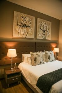 una camera da letto con un letto e due dipinti alle pareti di Walmer Manor Guest House a Port Elizabeth