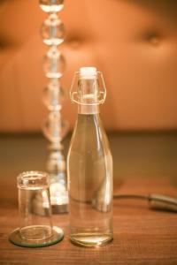 szklaną butelkę na drewnianym stole obok w obiekcie Walmer Manor Guest House w mieście Port Elizabeth