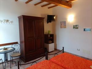 1 dormitorio con 1 cama, armario y mesa en Agriturismo Il Colto en San Gimignano