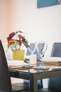 a table with two wine glasses on top of it at Snapos Apartments - Tudor Close in Carbrook