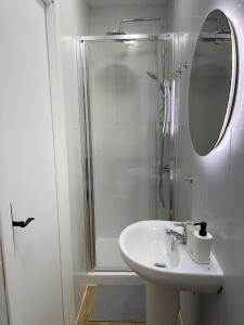 y baño con lavabo y ducha con espejo. en Precioso apartamento en el corazón de Madrid, en Madrid