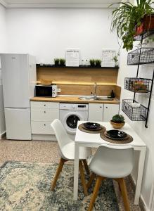 cocina con mesa blanca, sillas y fregadero en Precioso apartamento en el corazón de Madrid, en Madrid