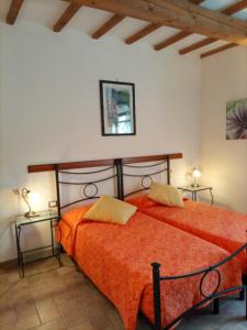 1 dormitorio con 2 camas con sábanas de color naranja en Agriturismo Il Colto, en San Gimignano