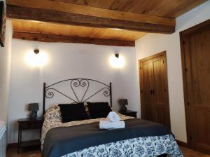 1 dormitorio con 1 cama en una habitación con techos de madera en CASA LARA CIUDAD ENCANTADA, en Valdecabras