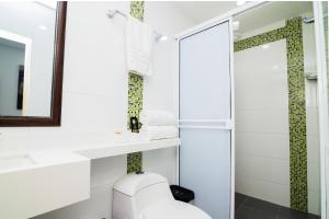 a bathroom with a toilet and a sink and a mirror at Hotel Gallery Cartagena in Cartagena de Indias