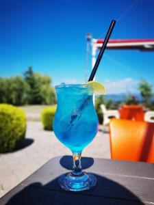 a blue drink with a lime on a table at Sunrise Hotel & Camping in Struga