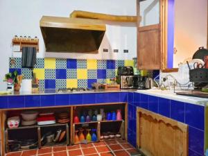 a kitchen with blue and yellow tiles on the wall at Ikali Hostel in Monterrey +49 photos