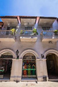 un edificio con tres ventanas y una tienda con ropa. en Hotel Gallery Cartagena, en Cartagena de Indias